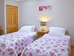two beds in a room with pink and white sheets at Beech Cottage - E4779 in Atwick