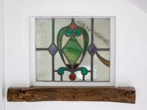 een glas-in-loodraam in een kamer met een vensterbank bij Brook Lodge in Bridford
