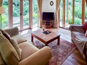 een woonkamer met een bank en een salontafel bij Brook Lodge in Bridford
