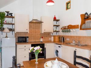 een keuken met een tafel met een vaas met bloemen bij Brook Lodge in Bridford