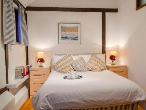 a bedroom with a bed and two night stands at The Dairy in Ninfield