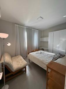 a bedroom with a bed and a table and a lamp at 4 quartos Conforto e silêncio no coração de BH in Belo Horizonte +22 photos