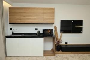 a kitchen with white cabinets and a black counter top at Royal Regency Eg Hotel in Cairo