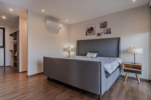 a bedroom with a large bed and a wooden floor at Elegante apartamento 3 recamaras Juriquilla in Juriquilla
