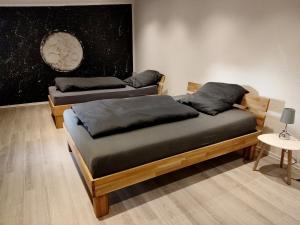 two beds in a room with a painting on the wall at Südeifel Spangdahlem in Spangdahlem