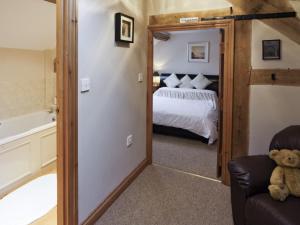 a bedroom with a bed and a tub in a room at Piglets Place - E4300 in Halston +3 photos