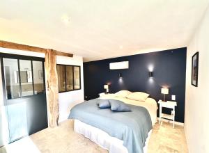 ein Schlafzimmer mit einem Bett und einer blauen Wand in der Unterkunft Villa Luceo Périgord 10p Piscine Clim in Coly
