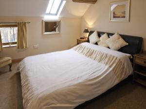 a bedroom with a large white bed with a window at Piglets Place - E4300 in Halston