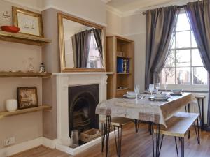 a dining room with a table and a fireplace at Divers Cottage in Herne Bay