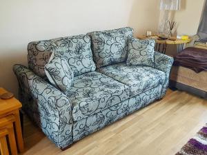 a gray couch in a living room with a table at Divers Cottage in Herne Bay