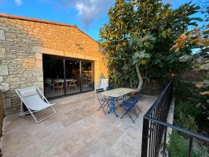 eine Terrasse mit Stühlen, einem Tisch und einem Zaun in der Unterkunft Le jardin de la Vade in Carcassonne