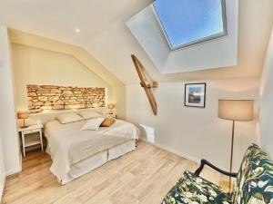 ein Schlafzimmer mit einem Bett und einem Dachfenster in der Unterkunft Villa Luceo Périgord 10p Piscine Clim in Coly