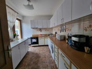 una cucina con mobili bianchi e un piano di lavoro in legno di Elysium Zenith Estate a Cornu de Jos