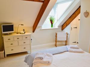 a bedroom with a bed and a tv and a window at Mainbrace in Port Isaac