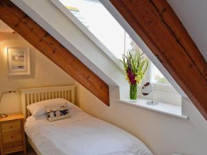 a bedroom with a bed and a window at Mainbrace in Port Isaac +2 photos