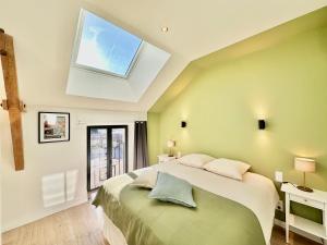 ein Schlafzimmer mit einem großen Bett mit Dachfenster in der Unterkunft Villa Luceo Périgord 10p Piscine Clim in Coly