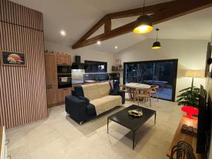 ein Wohnzimmer mit Sofa und Tisch in der Unterkunft Le jardin de la Vade in Carcassonne