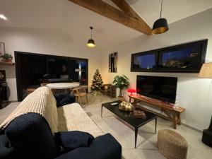 ein Wohnzimmer mit Sofa und Fernseher in der Unterkunft Le jardin de la Vade in Carcassonne