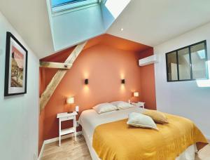 ein Schlafzimmer mit einer orangefarbenen Wand und einem Bett in der Unterkunft Villa Luceo Périgord 10p Piscine Clim in Coly