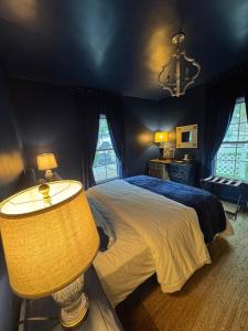 a bedroom with a large bed and a lamp at 5 BR 4 Bath Dutch Cottage 3 ml from Buffalo Trace in Frankfort