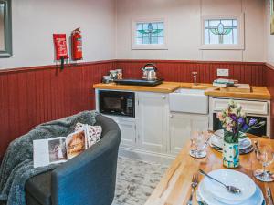 a kitchen with a table and a counter top with a table sidx sidx at Goosewing Hut-Qu7072 in Melton Constable +15 photos