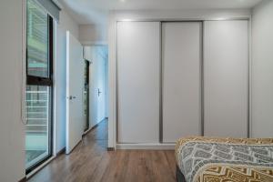 a bedroom with white walls and a bed and a window at Elegante apartamento 3 recamaras Juriquilla in Juriquilla