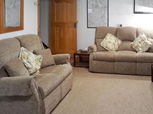 a living room with two couches and a table at Jebel Kasr in Braithwaite