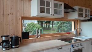 een keuken met een raam in een houten huisje bij Villa Leone in Nowe Warpno