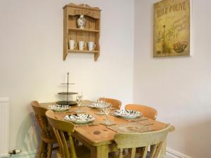 a wooden table with chairs and wine glasses on it at Lake View Apartment in Bowness-on-Windermere
