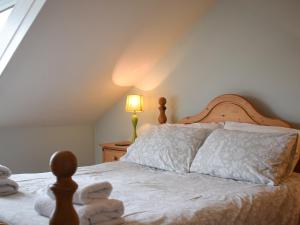 a bedroom with a bed with white sheets and a lamp at Lake View Apartment in Bowness-on-Windermere