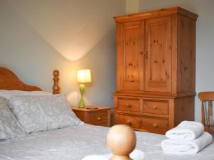 a bedroom with a large wooden cabinet and a bed at Lake View Apartment in Bowness-on-Windermere