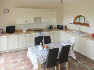 FilbyにあるThe Stablesのキッチンにテーブルと椅子がある