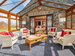 un salon avec des chaises et une table dans l'établissement Beacon Cottage, à Llanrian 24 autres photos