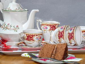 une table avec deux tasses à thé et une part de gâteau dans l'établissement Beacon Cottage, à Llanrian