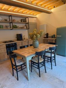 a wooden table with chairs and a vase on it at Dimora Segreta in Pienza +28 photos