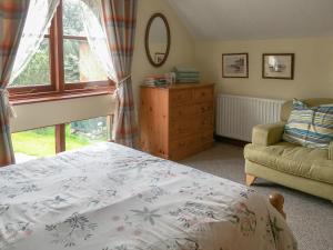 a bedroom with a bed and a chair and a window at Pheasant in Welney