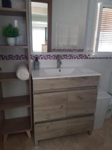 a bathroom with a sink and a mirror at Apartamento completo en Almonte centro con terraza in Almonte