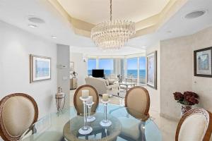 a dining room with a glass table and chairs at Spacious Three-Bedroom Oceanfront Apartment with Panoramic Views in Pompano Beach