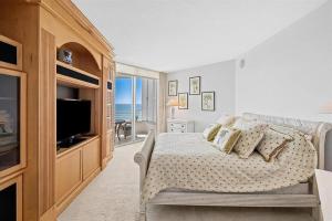 a bedroom with a bed and a television in a room at Spacious Three-Bedroom Oceanfront Apartment with Panoramic Views in Pompano Beach