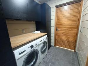 eine Waschküche mit einer Waschmaschine und einer Holztheke in der Unterkunft Naava Resort Luppo - Upea huvila järvinäkymällä in Ähtäri