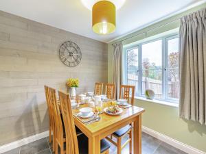 a dining room with a table and chairs and a clock at Humbug House in Lower Soudley