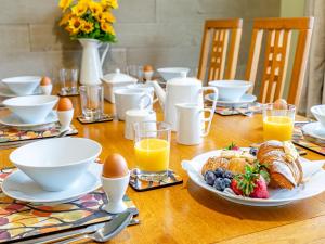 a table with a plate of breakfast food and eggs at Humbug House in Lower Soudley