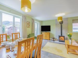 a dining room with a table and a fireplace at Humbug House in Lower Soudley +29 photos