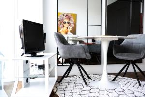 ブオクスにあるCharming studio by Lake Lucerneのテーブル、椅子2脚、テレビが備わる客室です。