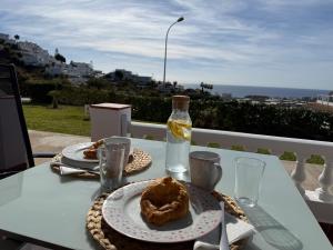 a table with a plate of food and a bottle of water at Mirador del Sol - Sea View Apartment Torrox in Torrox