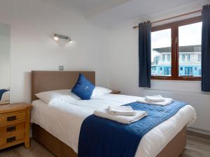 ロクサムにあるGrebeのタオルが敷かれたベッドのある寝室