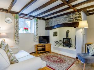 a living room with a white couch and a fireplace at The Tack Room - Uk30438 in Kingsbury Episcopi