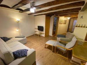 a living room with white couches and a tv at Casa Narcís in Claverol