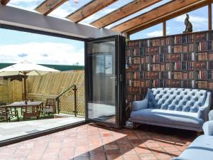 a living room with a couch and a wall of books at The Old Stables in Tickton