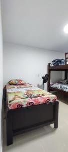 ein Schlafzimmer mit einem Bett mit einer Decke darauf in der Unterkunft Amplio Apartamento Renovado 150m2 para Familias, Grupos o Delegaciones Deportivas - Estadio Atanasio Girardot in Medellín